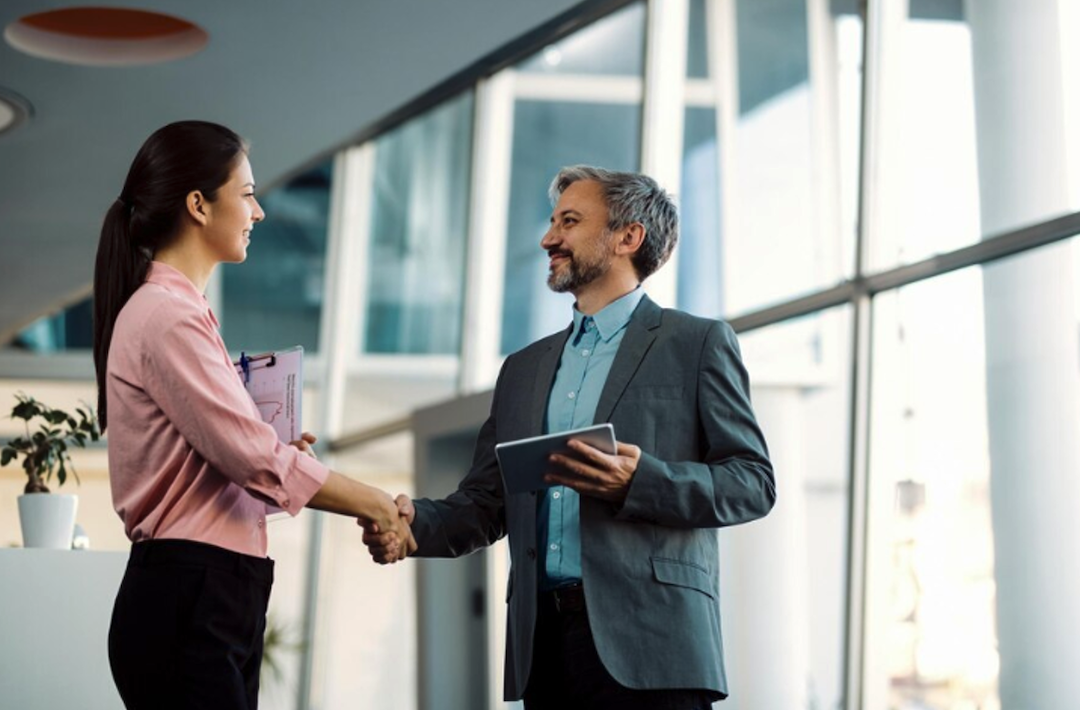 A man and woman shake hands