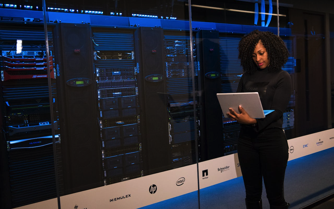 A woman standing by server racks