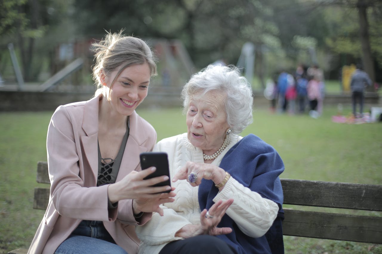 A woman helping elderly woman on smartphone