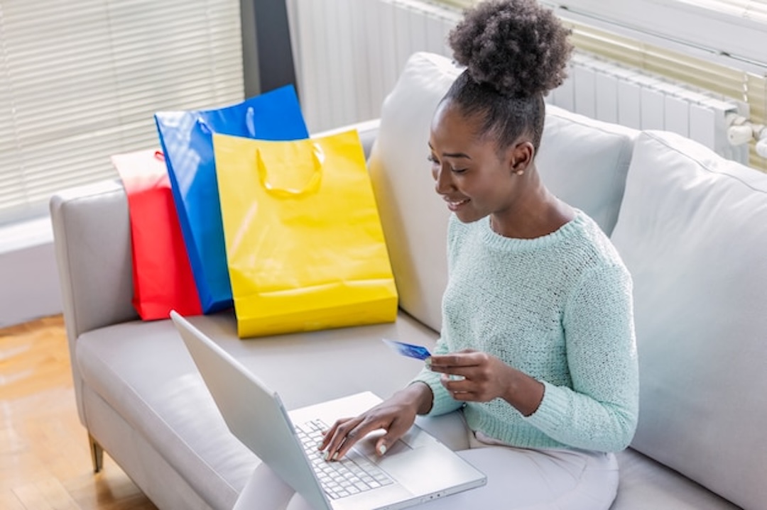 Woman holding credit card using laptop