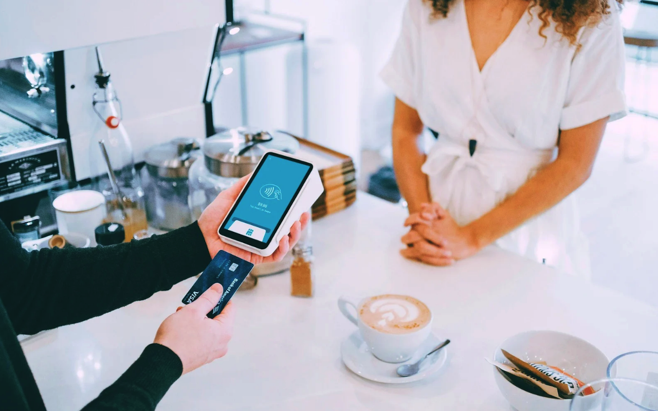 Customer use mobile payment at a café, showing how digital finance connects with modern bank account opening service trends
