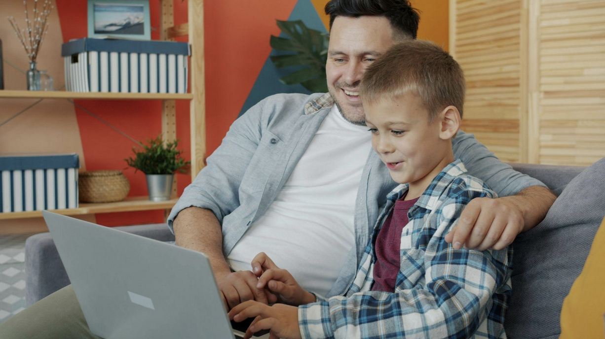 Parent and child using a laptop for digital learning at home