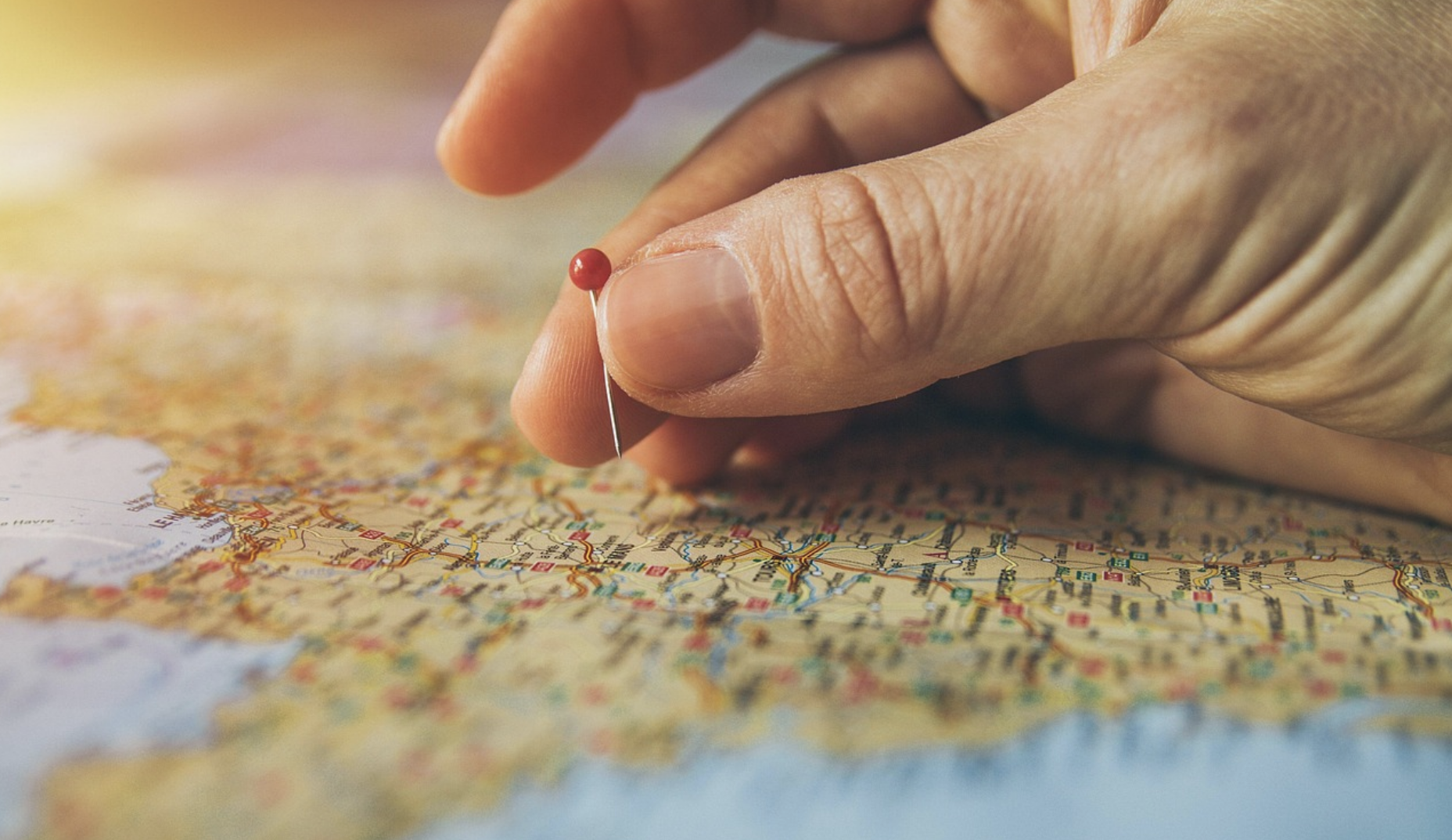 Person putting a pin on a map