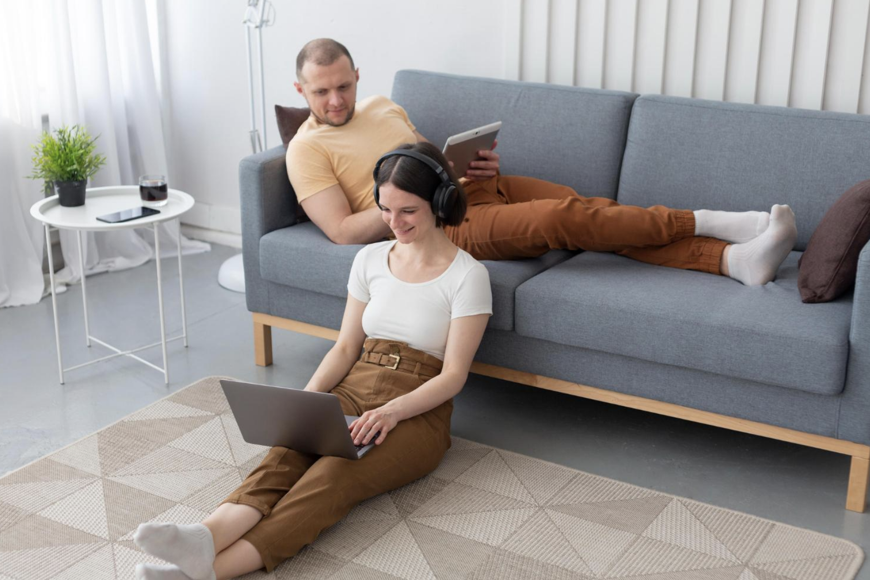 Two people using a laptop and iPad