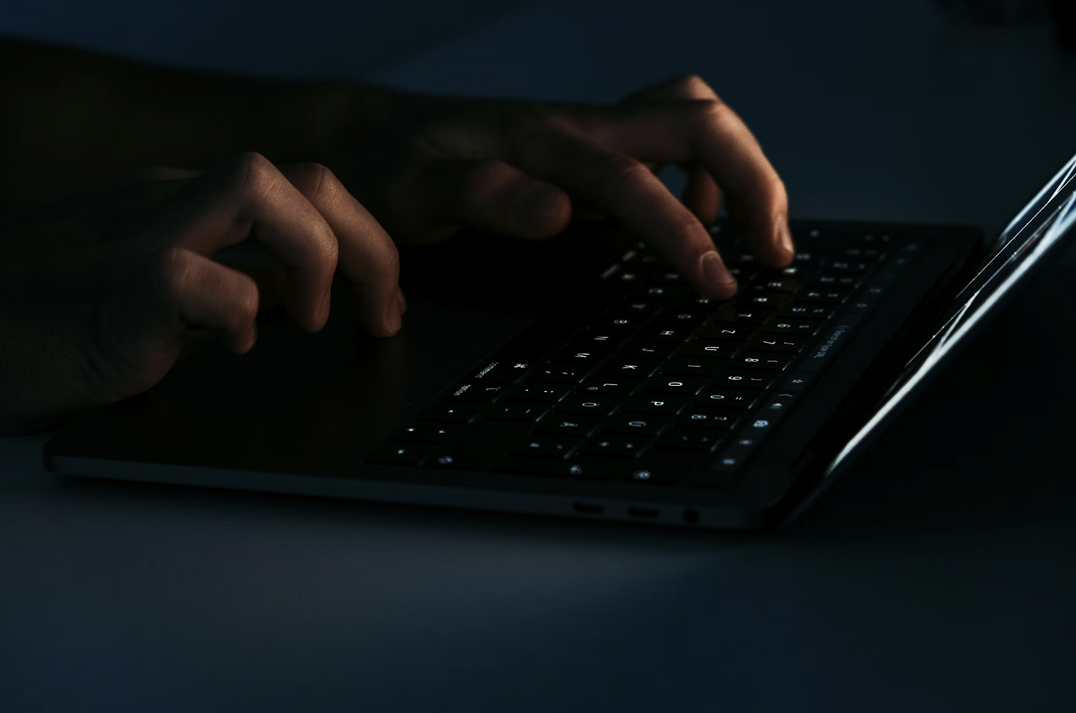 Fingers typing on a laptop keyboard