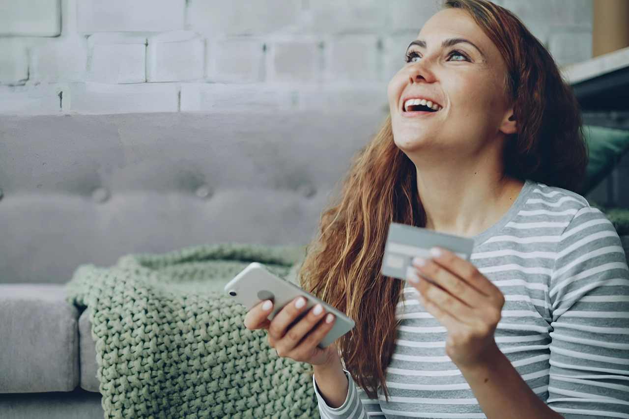 Woman holding credit card and phone
