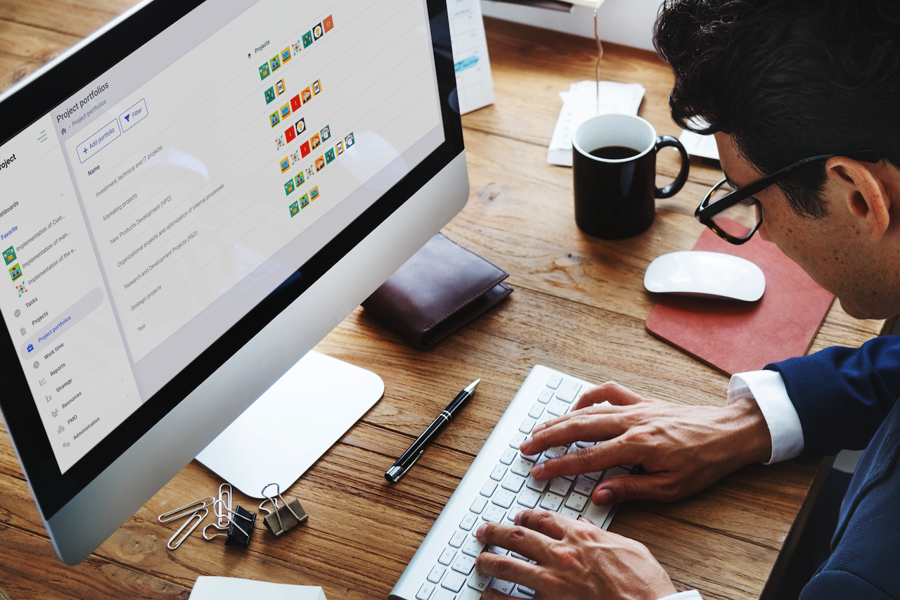 Project manager reviewing portfolio dashboard on desktop computer