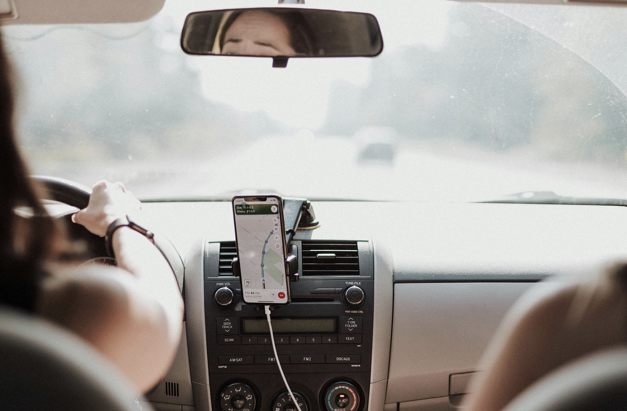 Person using GPS navigation on mobile phone in the car
