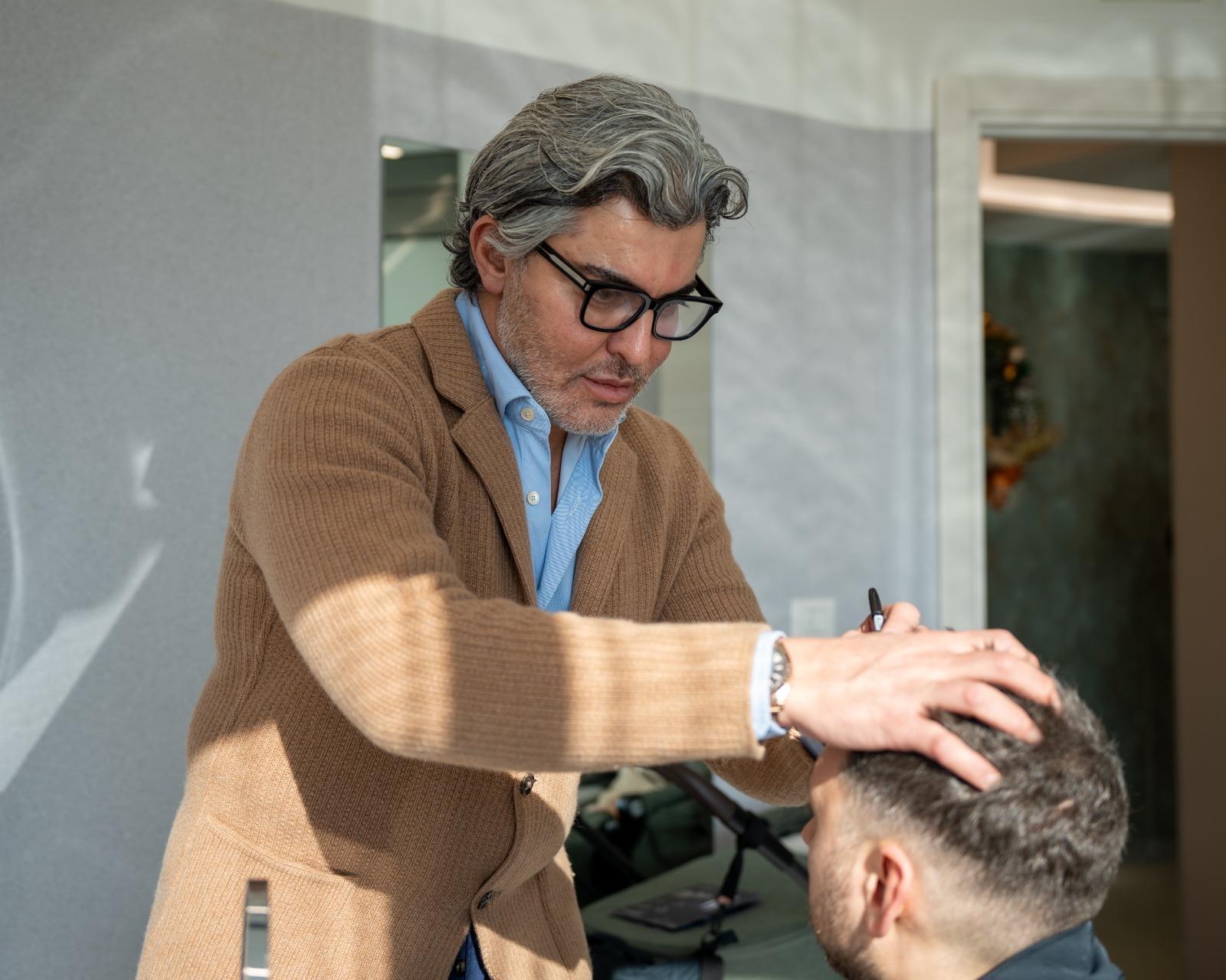 Person marking up hairline on client